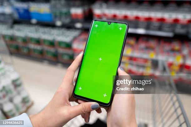 overlooking the green screen of the phone in front of the shelf - chroma key stock-fotos und bilder