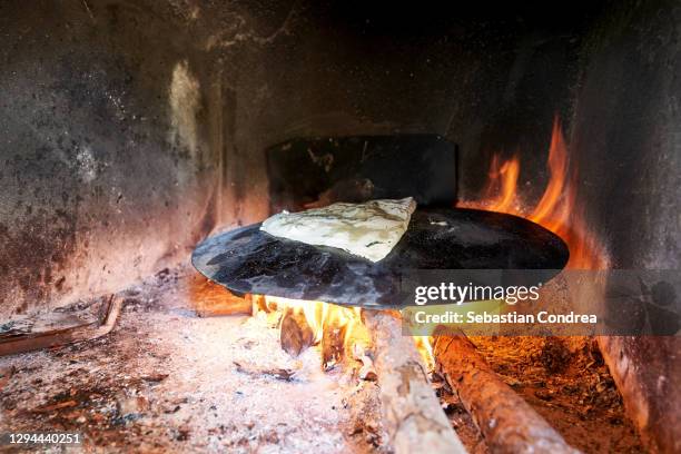 making gozleme bread on wooden fire in rural region in turkey 2020. - lavash stockfoto's en -beelden