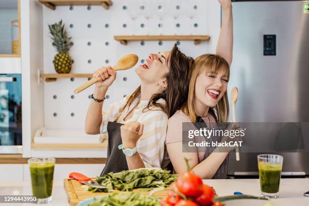 deux jeunes amis féminins cuisinant dans la cuisine - woman sing photos et images de collection