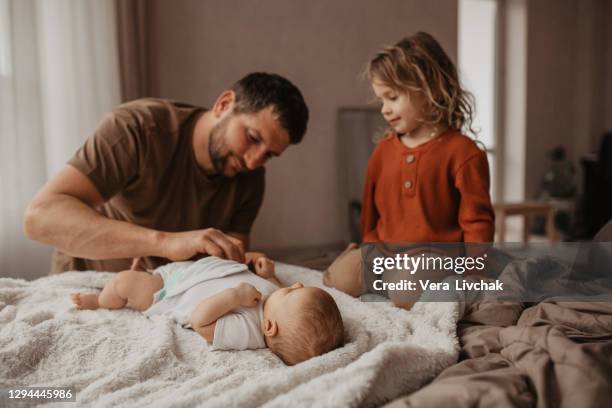 middle age caucasian father changing diaper for newborn baby daughter. male man parent taking care of child at home alone. authentic lifestyle candid moment. single dad family life concept. - changing diaper imagens e fotografias de stock