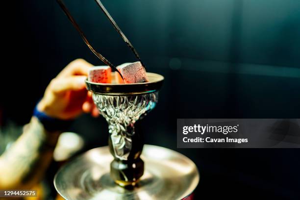 waiter placing smoking charcoal stones for shisha - cachimbo narguilé imagens e fotografias de stock