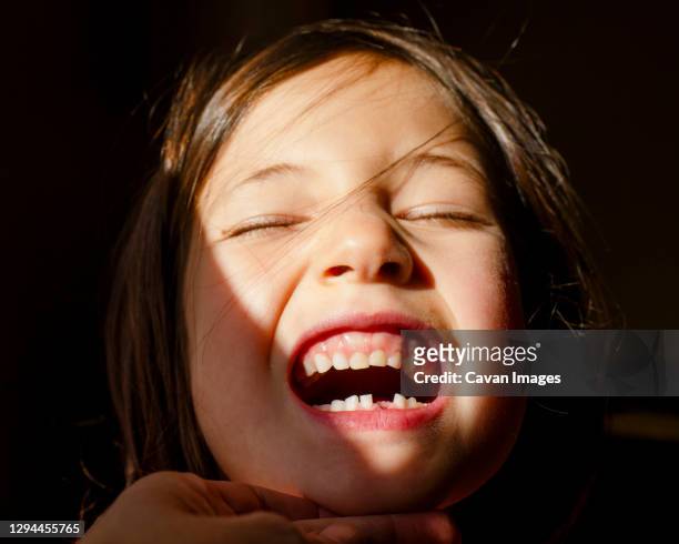 a small girl with eyes closed tilting up head to show first lost tooth - face eyes closed stock pictures, royalty-free photos & images