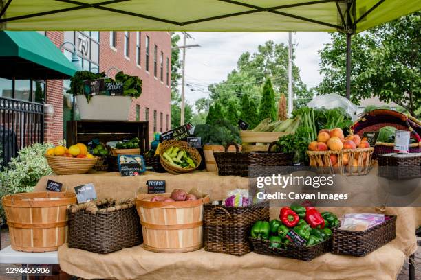 a small farm stand piled with baskets of fresh fruits and vegetables - canopy tent stock pictures, royalty-free photos & images