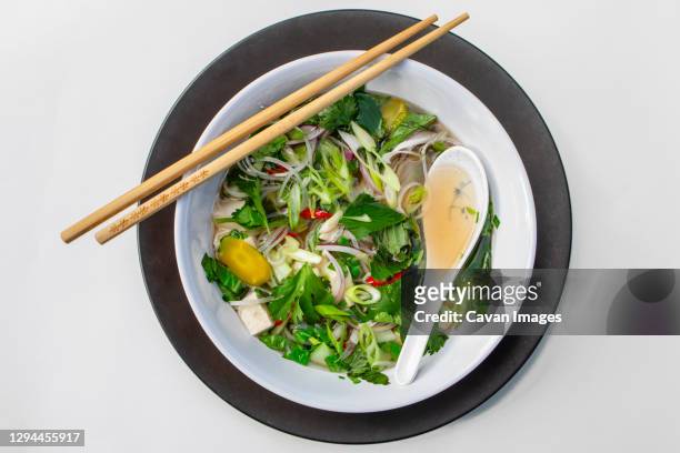above-view of bowl of asian noodle soup with chopsticks and spoon - pho soup stock-fotos und bilder