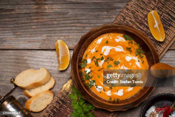 kürbissuppe auf einem teller serviert auf rustikalen holz tisch platte ansicht - pumpkin soup stock-fotos und bilder