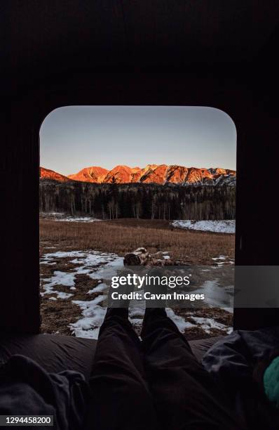 pov view of legs out camper door with mountain view sunset, colorado - silverton colorado foto e immagini stock