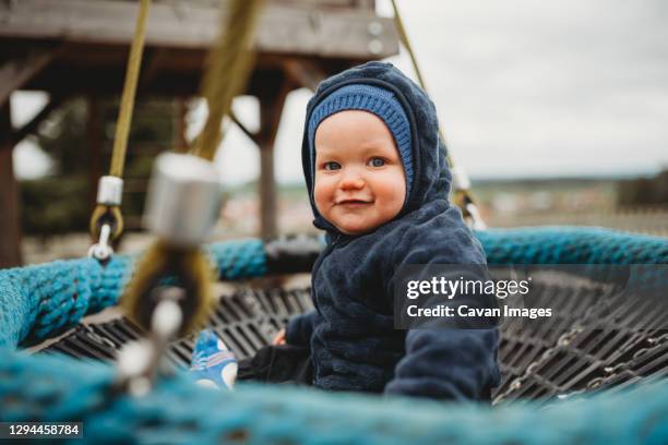 cute baby boy at a playground during winter - indoor kids play area stock-fotos und bilder