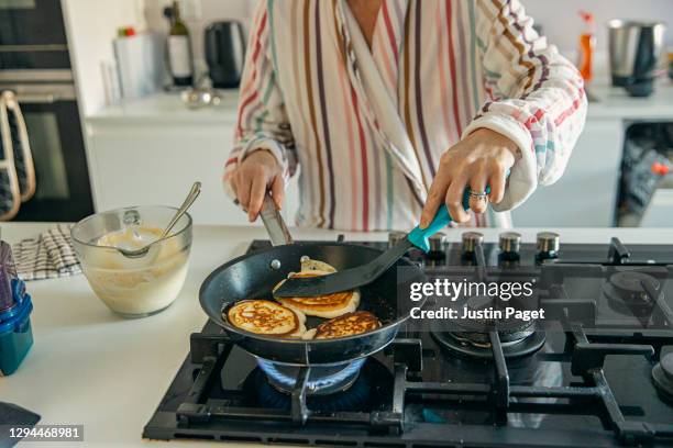 woman cooking homemade pancakes for breakfast - hob fotografías e imágenes de stock