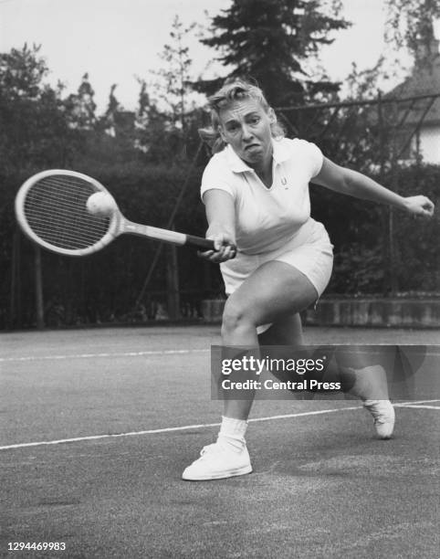 Darlene Hard of the United States reaches to make a forehand return during practice for her Women's Singles match at the Surrey Hard Court...