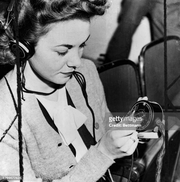 Betty Stark, secretary to Colonel Telford Taylor, of the U.S. Executive staff at the trials, is operating the interpreter dial that goes with each...