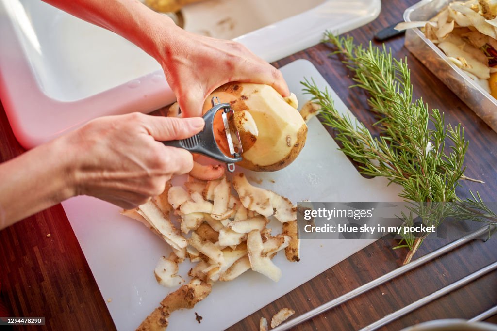 Peeling Potatoes in the kitchen with Rosemary in the background