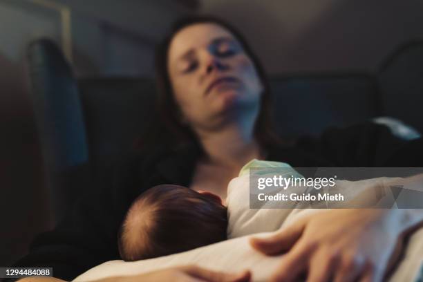 exhausted mother doing breastfeeding at home at night. - dark baby stock pictures, royalty-free photos & images