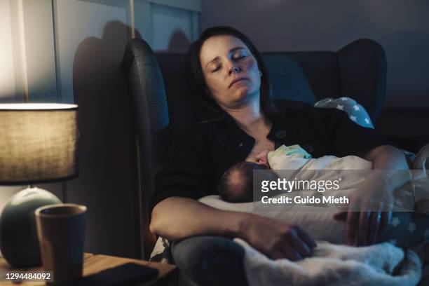 sleeping mother doing breastfeeding at home at night. - mutter baby stock-fotos und bilder