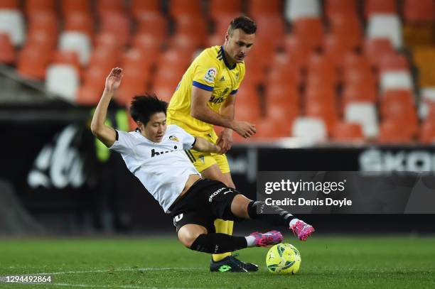 Lee Kang-In of Valencia is challenged by Cala of Cadiz CF during the La Liga Santander match between Valencia CF and Cadiz CF at Estadio Mestalla on...