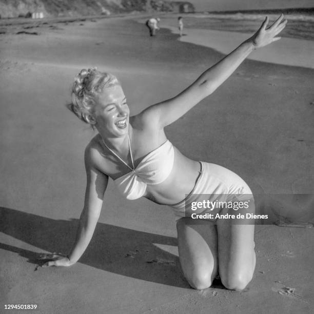 Portrait of American actress and model Marilyn Monroe in a two-piece swimsuit, as she poses on a beach, Malibu, California, 1946.