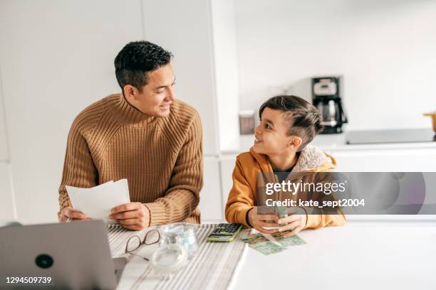 arbeiten von zu hause und zu hause mit kind im grundschulalter - eltern geld stock-fotos und bilder