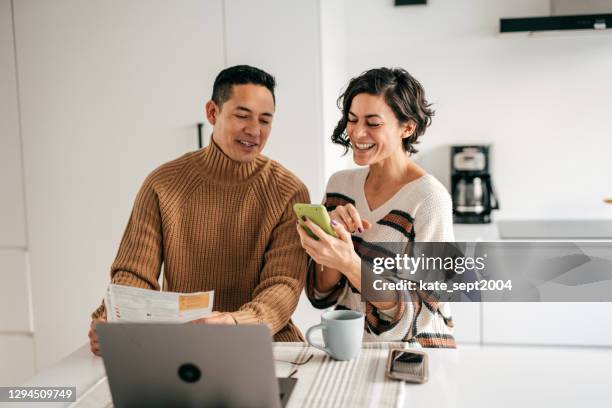 online banking per il budget familiare - coppia in cucina con bollette - home finances foto e immagini stock