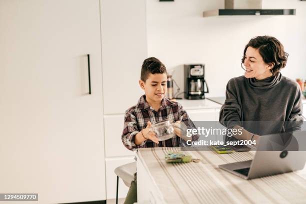 saving tips. kid counting cash in the kitchen - boys money stock pictures, royalty-free photos & images