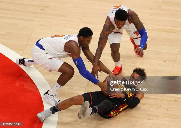 Trae Young of the Atlanta Hawks battles for a loose ball against RJ Barrett and Elfrid Payton of the New York Knicks during the first half at State...