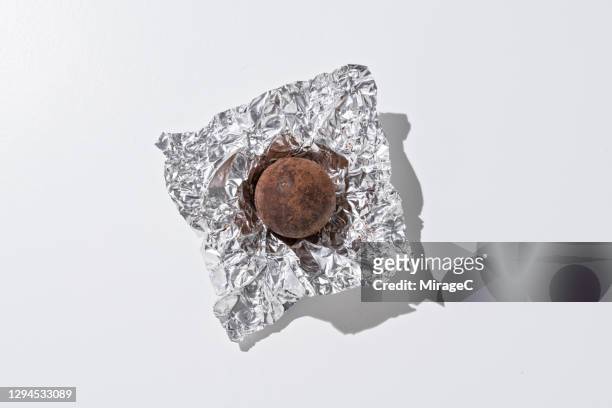 dark chocolate truffles in foil - chocolate foil stock-fotos und bilder