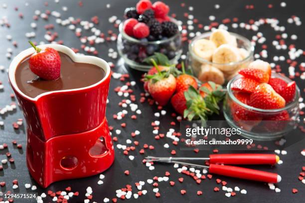 table set for a romantic occasion on valentine's day with chocolate fondue and fruits - chocolate fondue stock pictures, royalty-free photos & images