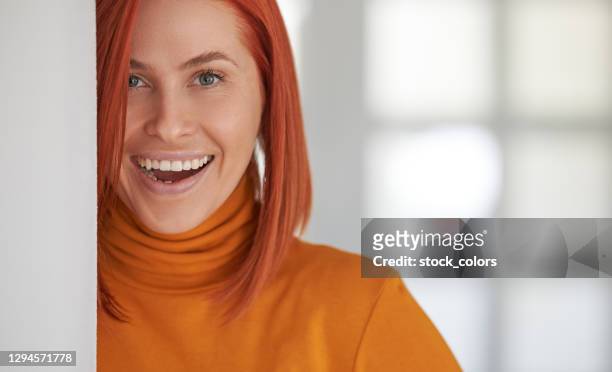 happy redhead posing indoors at wall - beautiful romanian women stock pictures, royalty-free photos & images