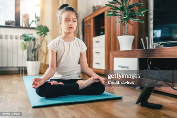 yoga training online. cute girl at home with digital tablet in lotus position - lotus position stock pictures, royalty-free photos & images