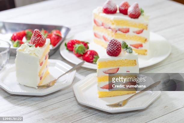 strawberry and cream sponge cake on white wooden table - cake slices imagens e fotografias de stock
