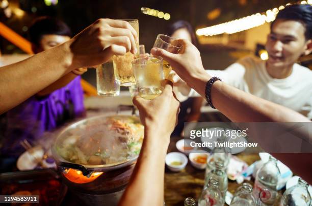 grupo de jóvenes amigos asiáticos que tienen fiesta bebiendo cerveza y comiendo olla caliente local al estilo tailandés en el restaurante al aire libre - hot pot dish fotografías e imágenes de stock