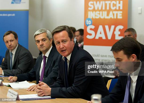 Prime Minister David Cameron addresses a meeting of energy heads flanked by his energy secretary Chris Huhne , during a summit on gas and electricity...