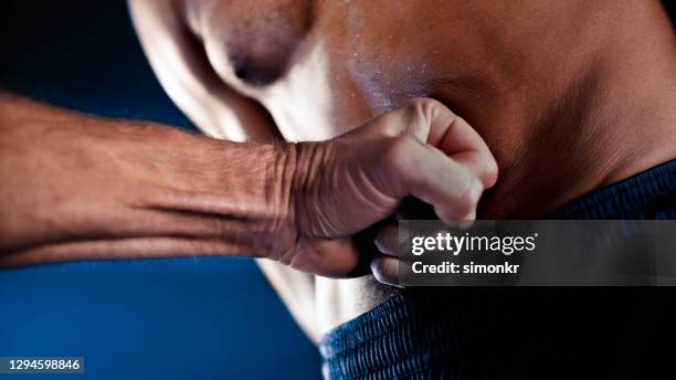 nahaufnahme des mannes wird in den magen gestochen - belly punching stock-fotos und bilder
