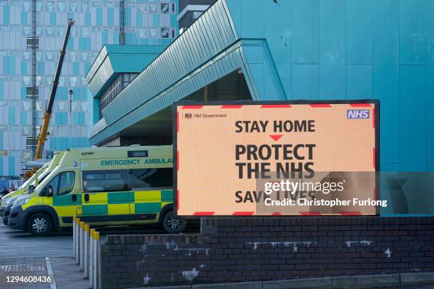 Ambulances line up as a electronic sign funded by the trust gives out coronavirus pandemic information to visitors and staff at the Aintree...