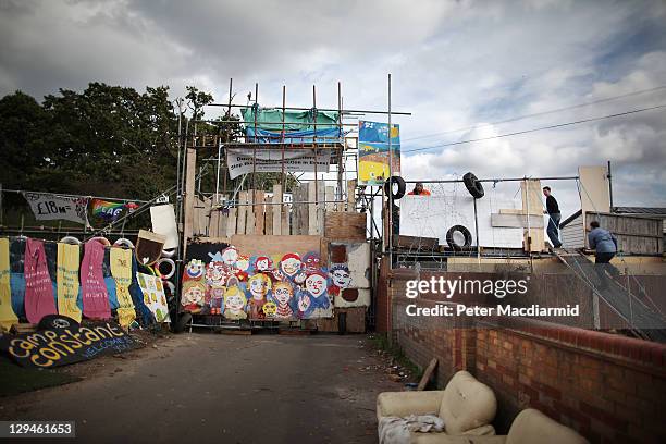 Residents climb a ramp on a barricade at Dale Farm travellers camp on October 17, 2011 near Basildon, England. Residents of the illegal camp are...