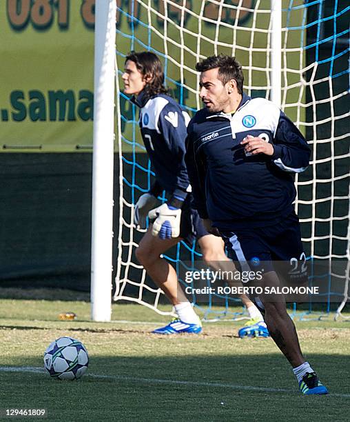 Napoli's forward Edinson Cavani takes a turn as goalkeeper as teammate Ezequiel Lavezzi controls the ball during a training session at SSC Napoli's...