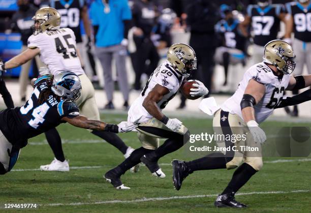 Running back Ty Montgomery of the New Orleans Saints attempts to break a tackle from linebacker Shaq Thompson of the Carolina Panthers during the...