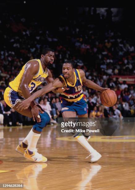 Fat Lever, Point Guard and Shooting Guard for the Denver Nuggets dribbles the basketball past Magic Johnson of the Los Angeles Lakers during their...