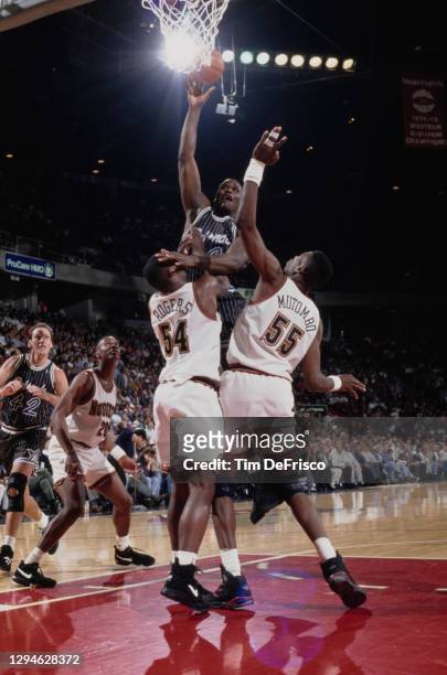 Shaquille O'Neal, Center for the Orlando Magic rolls a layup to the hoop as Dikembe Mutombo and Rodney Rogers of the Denver Nuggets attempts to block...