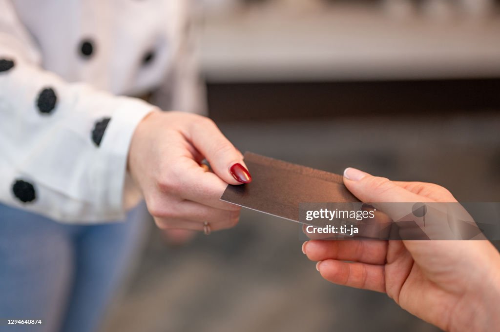 Hands passing a blank business card
