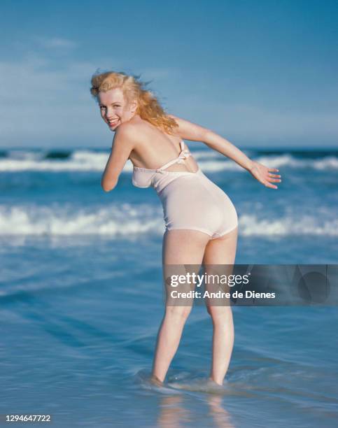 Portrait of American actress and model Marilyn Monroe , in a white swimsuit, as she poses on Long Island's Tobay Beach, Oyster Bay, New York, 1949.