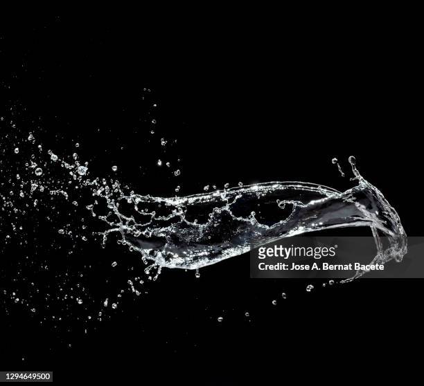 splashes, jet and drops of water in motion suspended in the air on a black background. - zusammenprall stock-fotos und bilder
