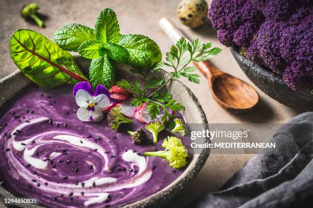 sopa de coliflor púrpura woth patatas moradas en un tazón con hierbas - comida flores fotografías e imágenes de stock