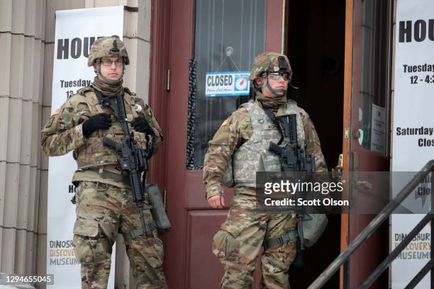 National guard troops stand guard near of the Kenosha County Courthouse as they wait for an announcement from the Kenosha district attorney on...