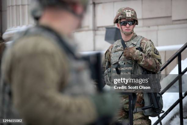 National guard troops stand guard near of the Kenosha County Courthouse as they wait for an announcement from the Kenosha district attorney on...