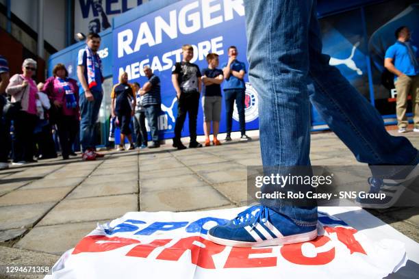 V HAMILTON.IBROX - GLASGOW.A fan stands on a Sports Direct banner as he makes his way inside the stadium