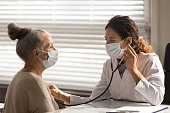 Female doctor listen to senior patient heart