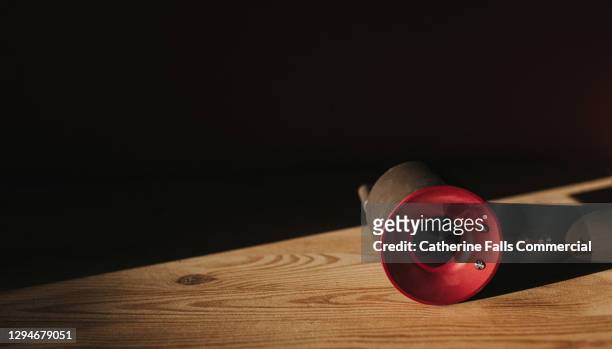 modern hairdryer lying on side on a wooden table in shadow - secador de cabelo - fotografias e filmes do acervo
