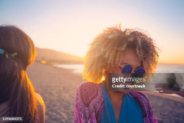 woman dancing on the beach with friends at sunset or sunrise. - lens flare young people dancing on beach stock pictures, royalty-free photos & images