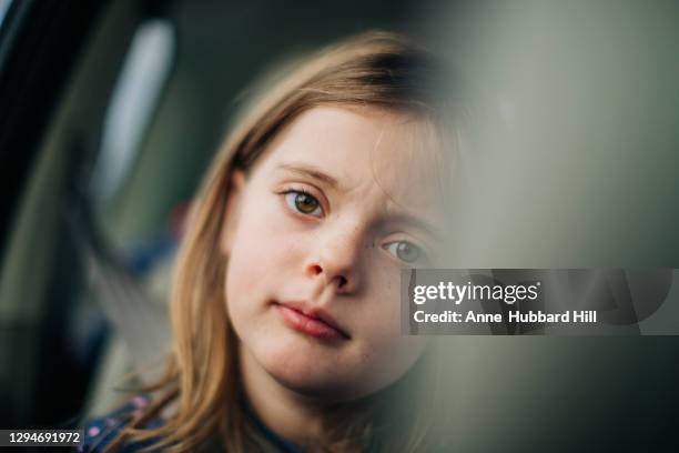 young girl in back seat of car looks annoyed - back seat stock pictures, royalty-free photos & images