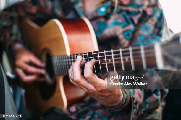 close up of person playing traditional acoustic guitar - acoustic guitar stock-fotos und bilder