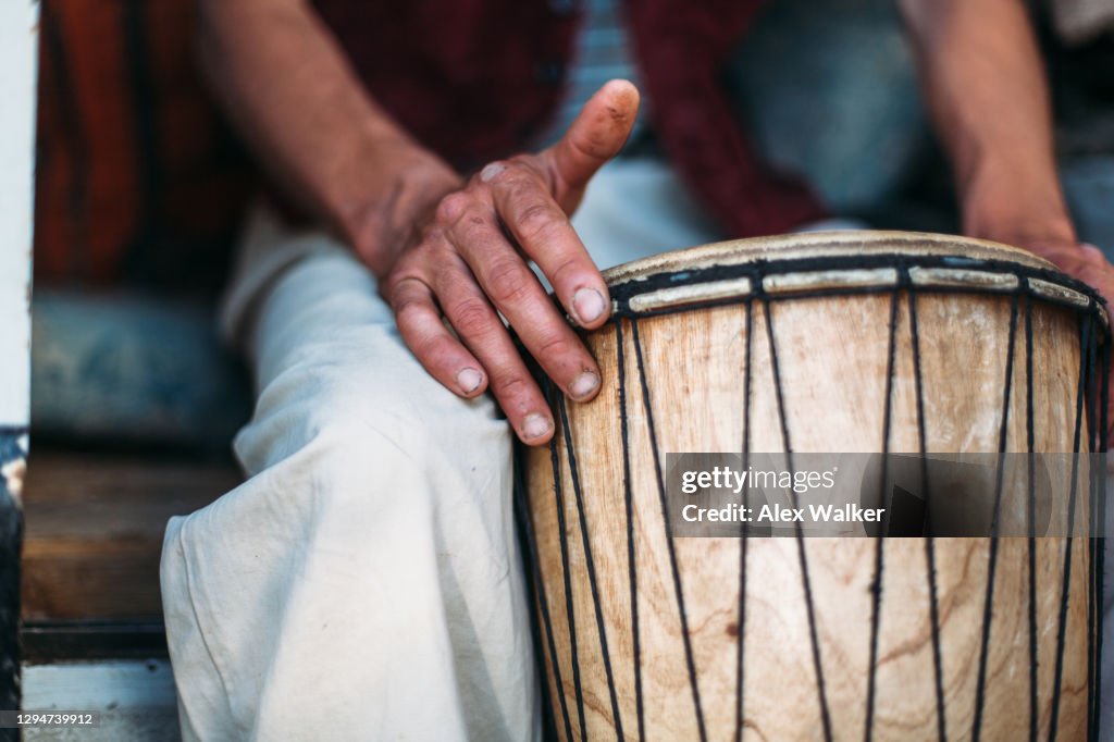 Close up of drum head with person's hand